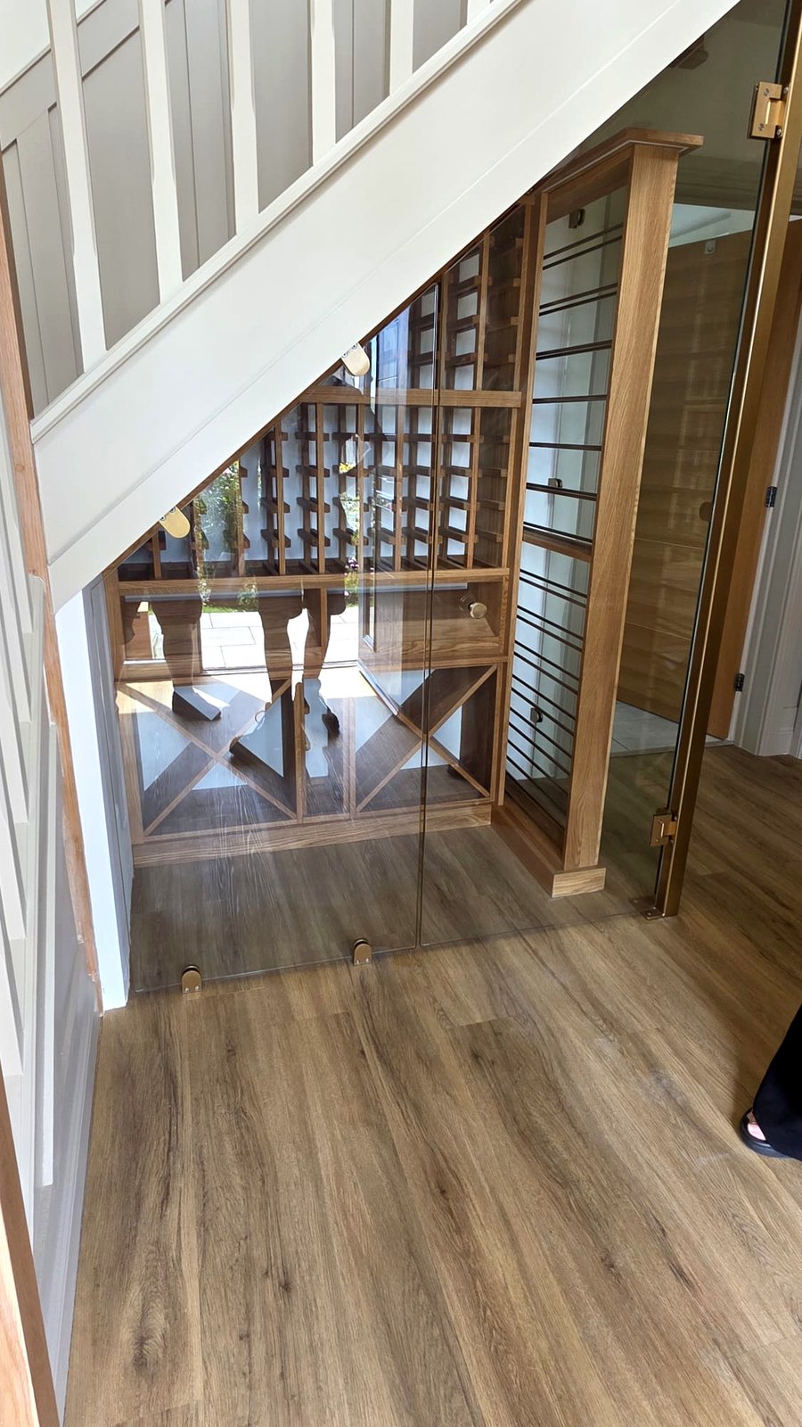 Hinged glass under-stairs door open to wine racking by Wineracks UK, Warrington